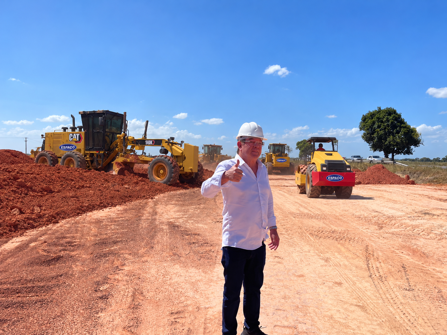 Obra em andamento com máquinas pesadas e representante da empresa em campo